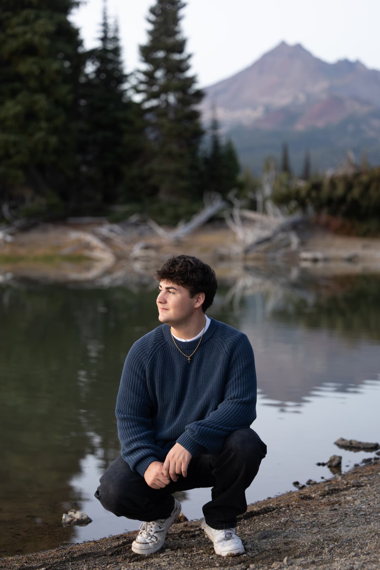 Senior guy kneeling beside a mountain lake in Central Oregon