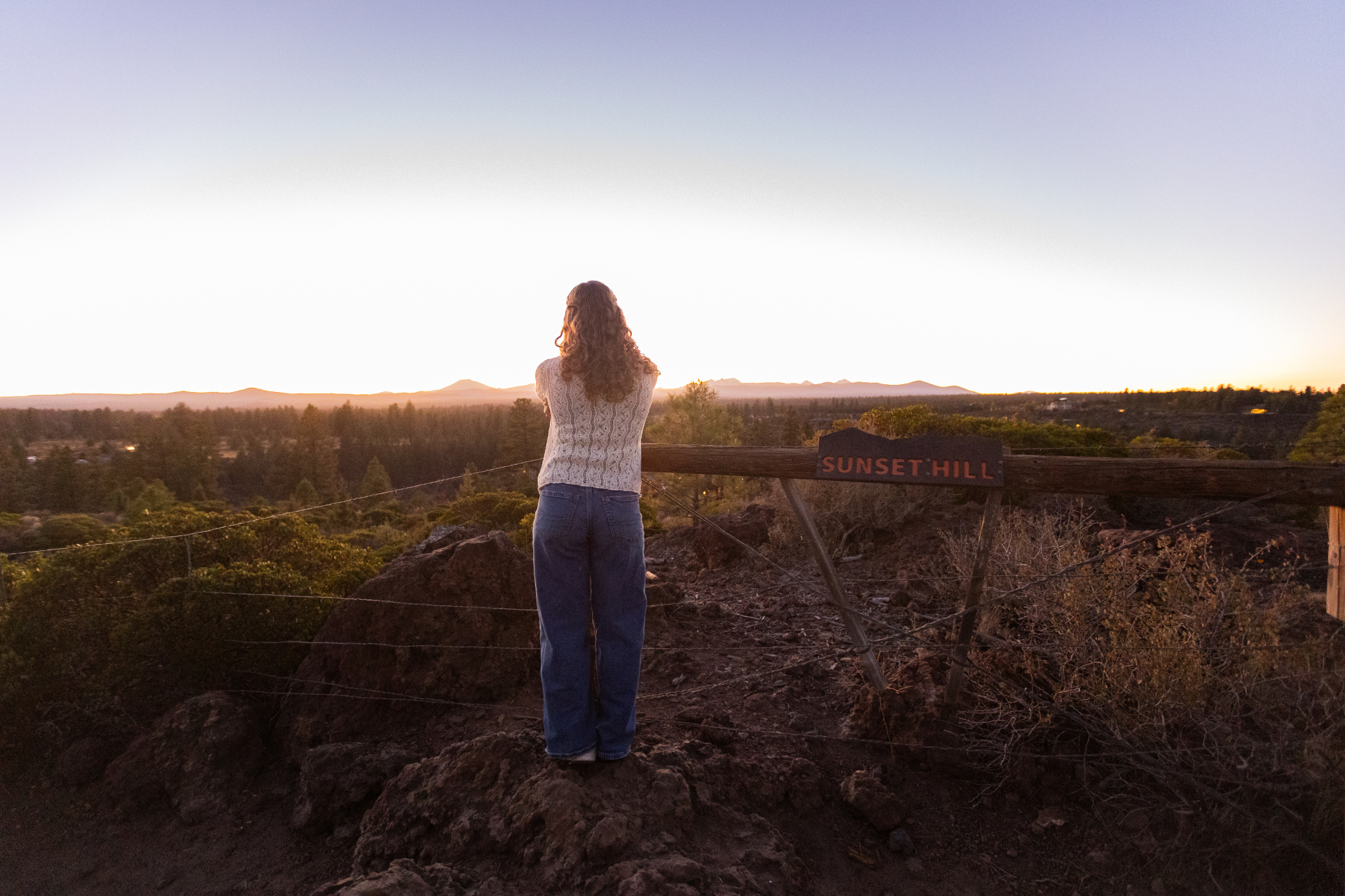 Senior girl looking toward the sunset and Cascade mountains from Sunset Hill